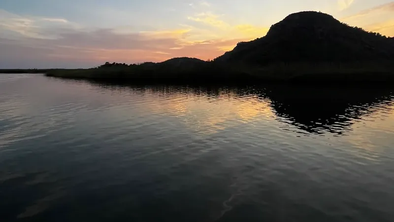 Alacakaranlıkta tepe silueti ve Dalyan Çayı sazlıkları Alacakaranlıkta tepe silueti ve Dalyan Çayı sazlıkları