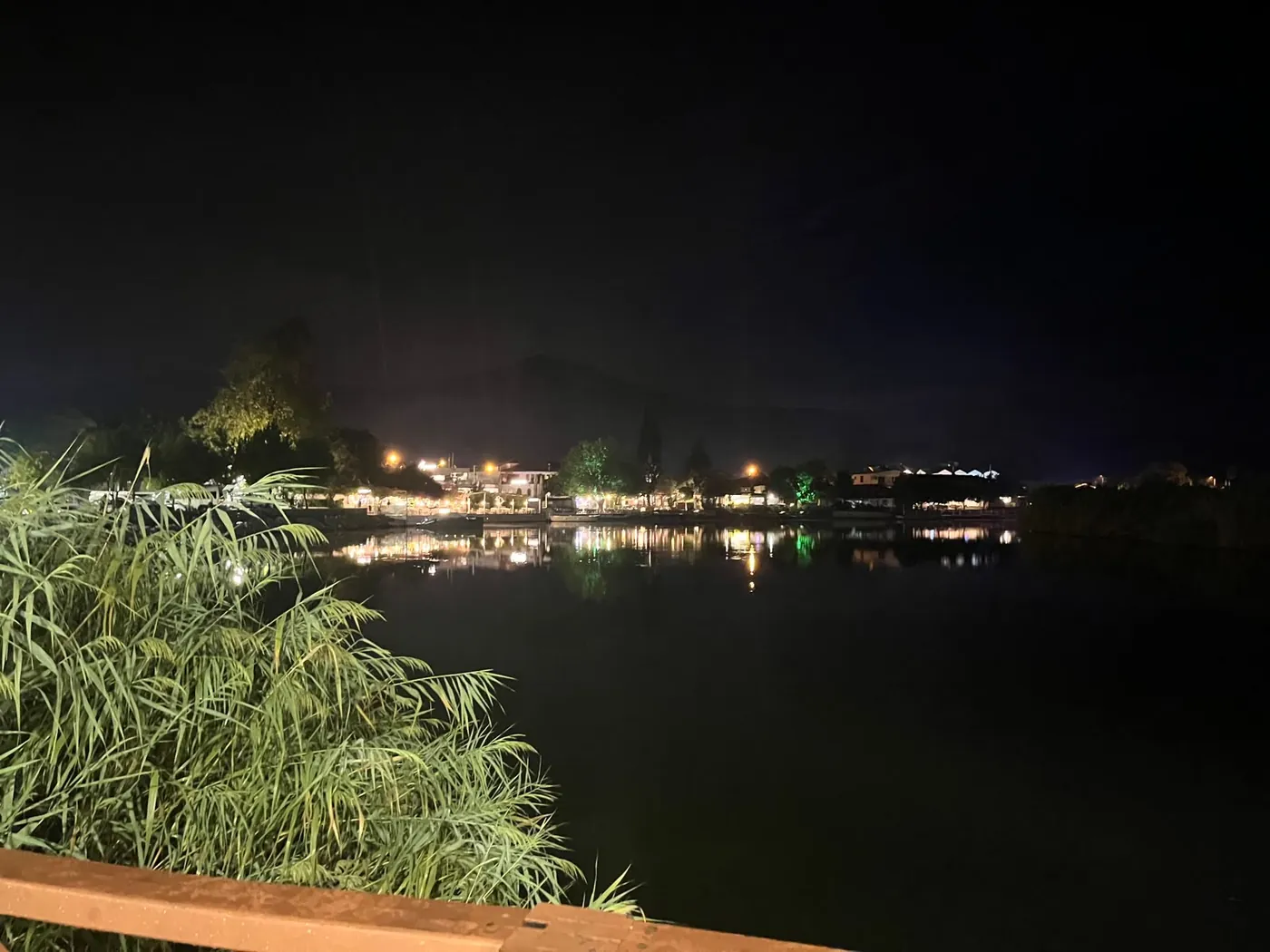 Still water on the Dalyan river carrying the reflection of the town lights Still water on the Dalyan river carrying the reflection of the town lights