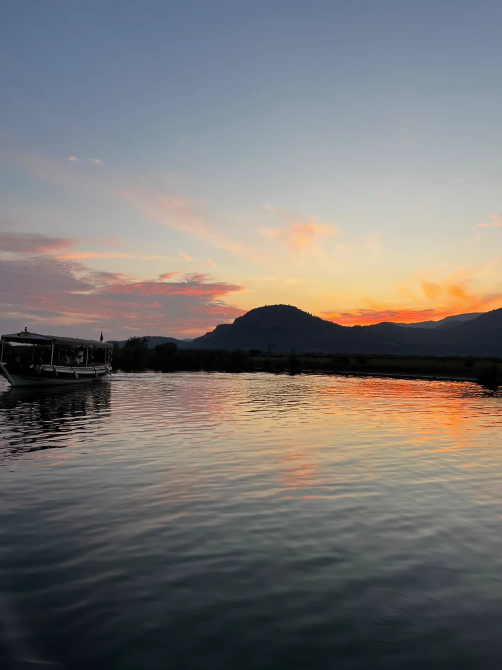 Ein Ausflugsboot auf dem Fluss bei Sonnenuntergang