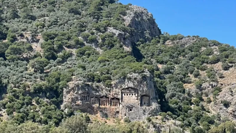 A Dalyan tour boat passing below the rock tombs A Dalyan tour boat passing below the rock tombs