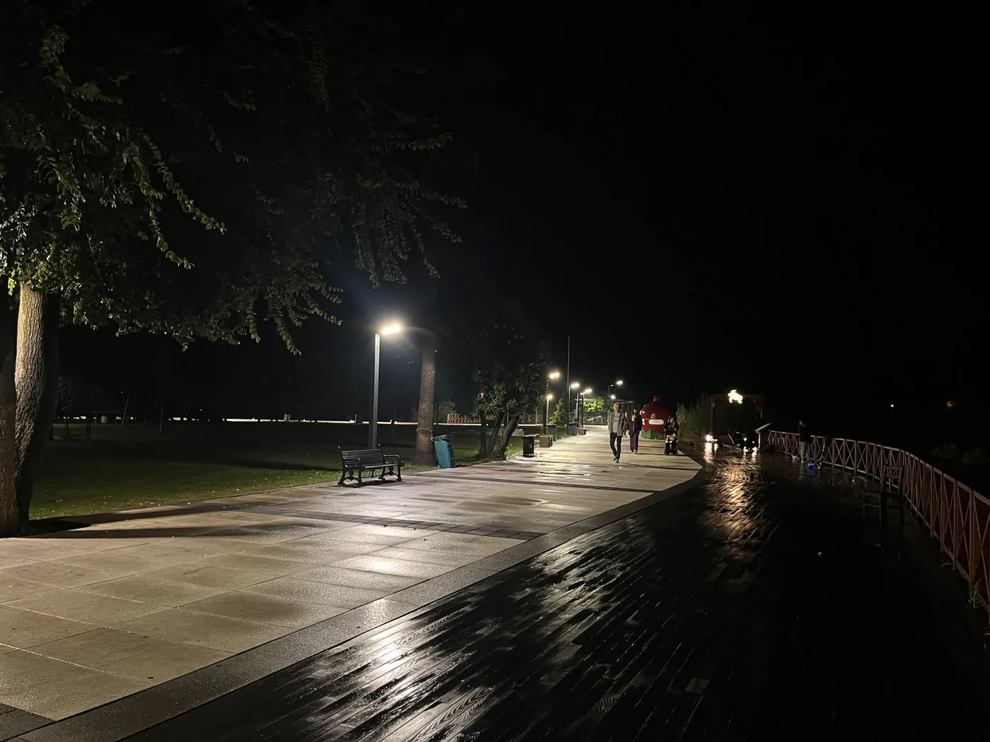 Der Holzsteg entlang der Promenade, darüber Bäume und Bänke Der Holzsteg entlang der Promenade, darüber Bäume und Bänke