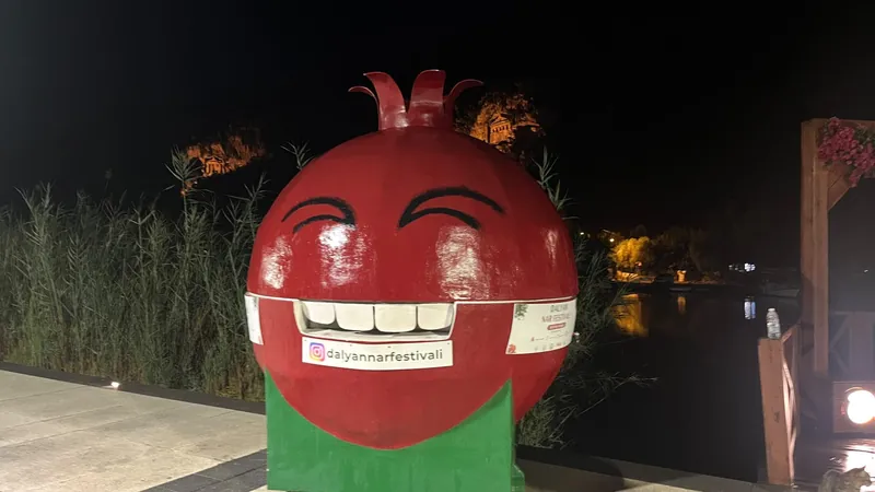 Das lächelnde Granatapfel-Maskottchen des Granatapfelfestes von Dalyan nachts an der Uferpromenade Das lächelnde Granatapfel-Maskottchen des Granatapfelfestes von Dalyan nachts an der Uferpromenade