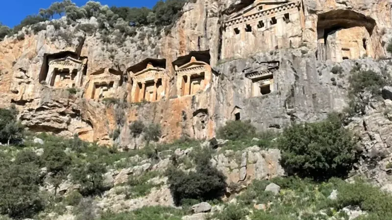 Ein steiler Blick die Felswand hinauf zur Reihe der Gräber Ein steiler Blick die Felswand hinauf zur Reihe der Gräber
