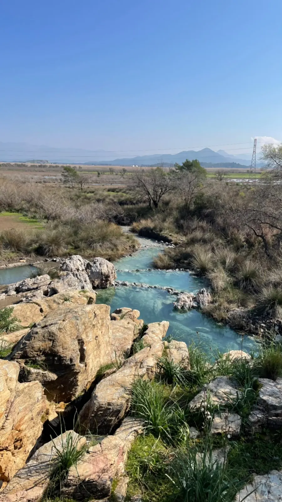 A warm stream winding between travertine ledges in winter A warm stream winding between travertine ledges in winter